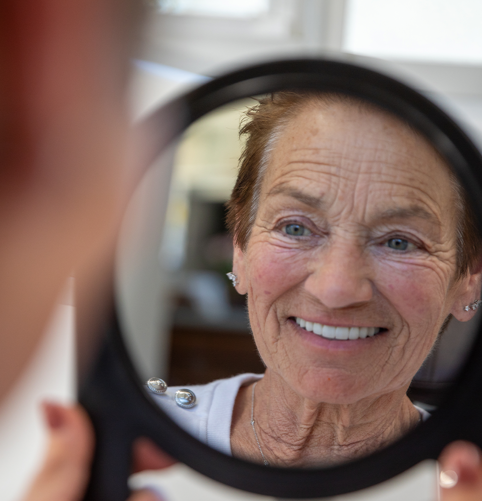 patient smiling in dental mirror